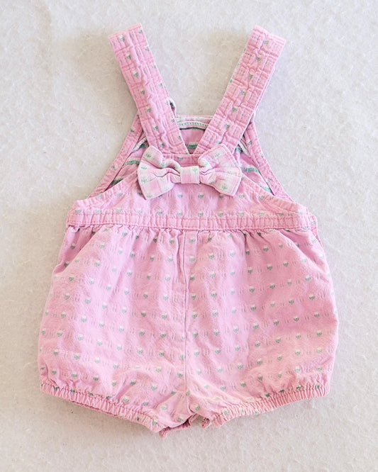 Vintage OshKosh B'Gosh girls pink floral shortall size 18 months, front flat lay, adjustable quilted straps, bow back