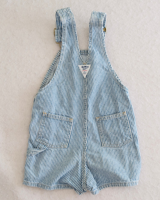 Vintage OshKosh B'Gosh kids blue and white hickory stripe shortalls size 4T, front flat lay, bib front pocket with navy OshKosh label,