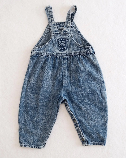 Vintage OshKosh B'gosh blue acid wash overalls with pink label and embossed OshKosh girl on back