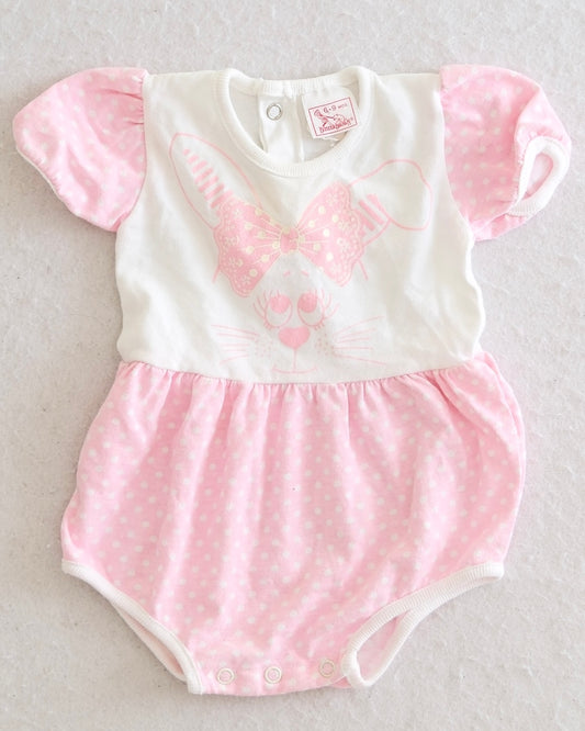 Vintage Buster Brown girls pink white polka dot bunny romper size 6-9 months, front flat lay, screen print bunny face with bow, puff sleeves, gathered skirt overlay, snap bottom closure