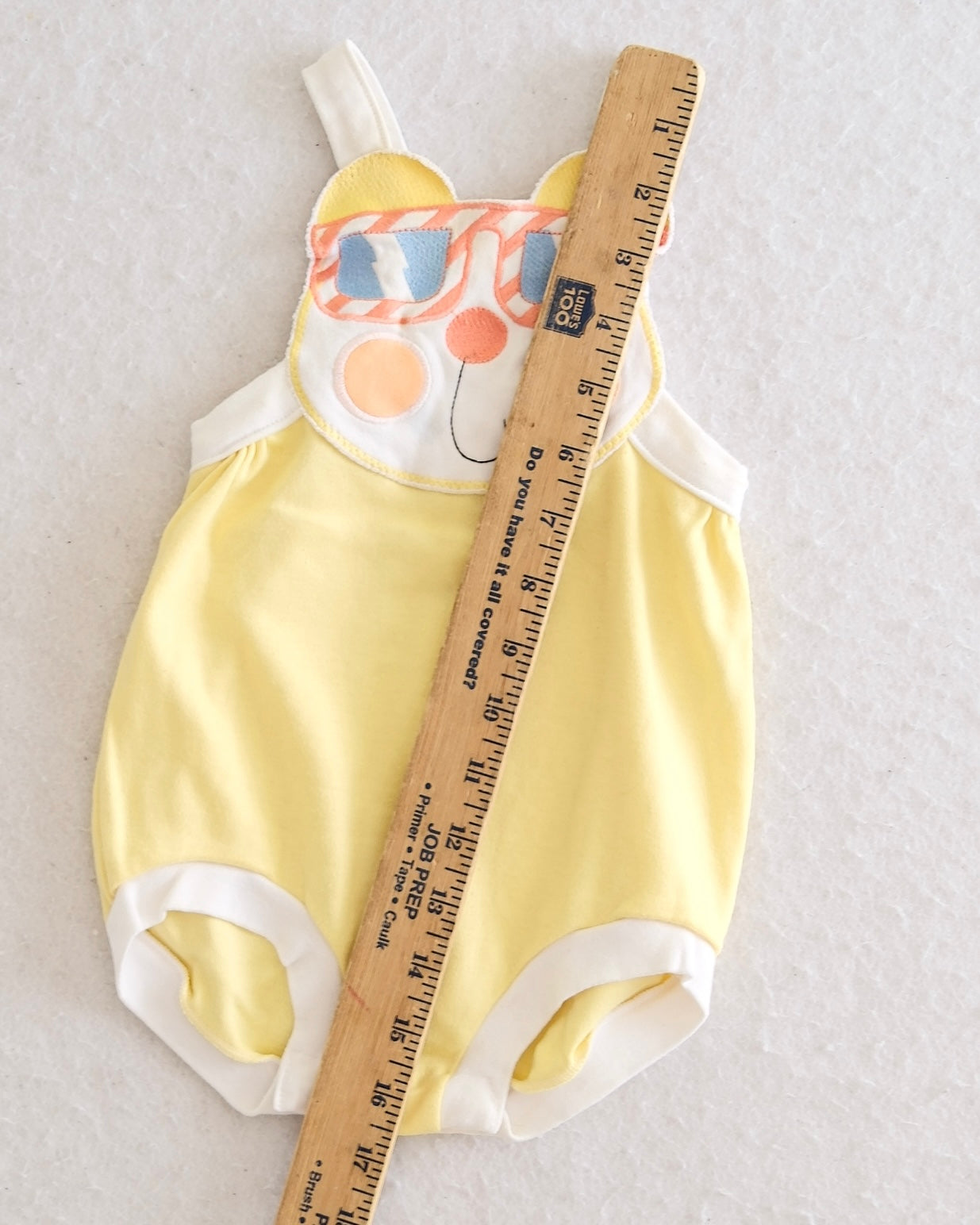Vintage Carter's unisex butter yellow bubble romper size 24 months, front flat lay, appliqué bear face with striped sunglasses on white bib, adjustable straps, white bound leg openings, Made in USA