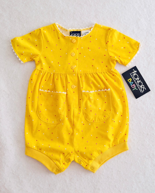 Yellow baby romper with red polka dots on a white background
